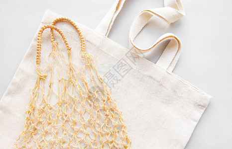 白色背景上的可重复使用的购物袋生态概念网袋和棉袋的顶视图关爱环图片