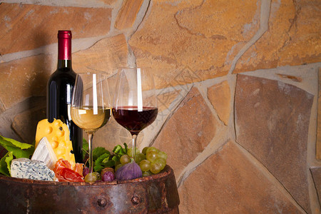 在酒窖的旧桶子旁边加起司香肠和水果葡萄品尝概念文本室图片
