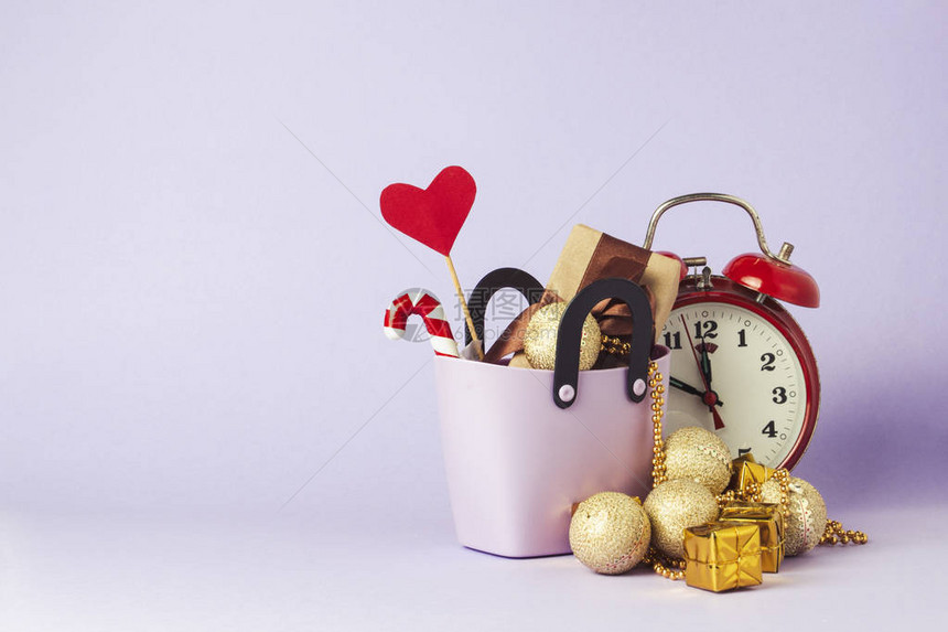购物用小塑料袋礼品盒棍子上的心红色闹钟圣诞装饰品紫罗兰色背景节前购物圣诞销售黑色星期五网络图片