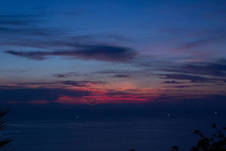 泰国普吉PhuketThailand的KaronViewpoint上方看到黑暗和充满活力的日落海洋云层厚背景图片