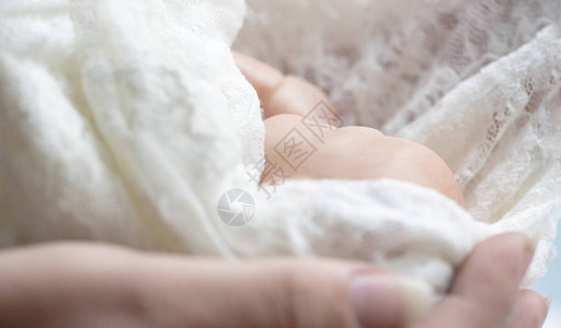 与母亲手包着带条的新生儿早产婴儿背景图片