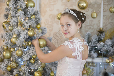 聪明的女孩装饰一棵圣诞树有圣诞树玩具图片
