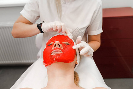 美容师将滋养面膜敷在患者脸上图片