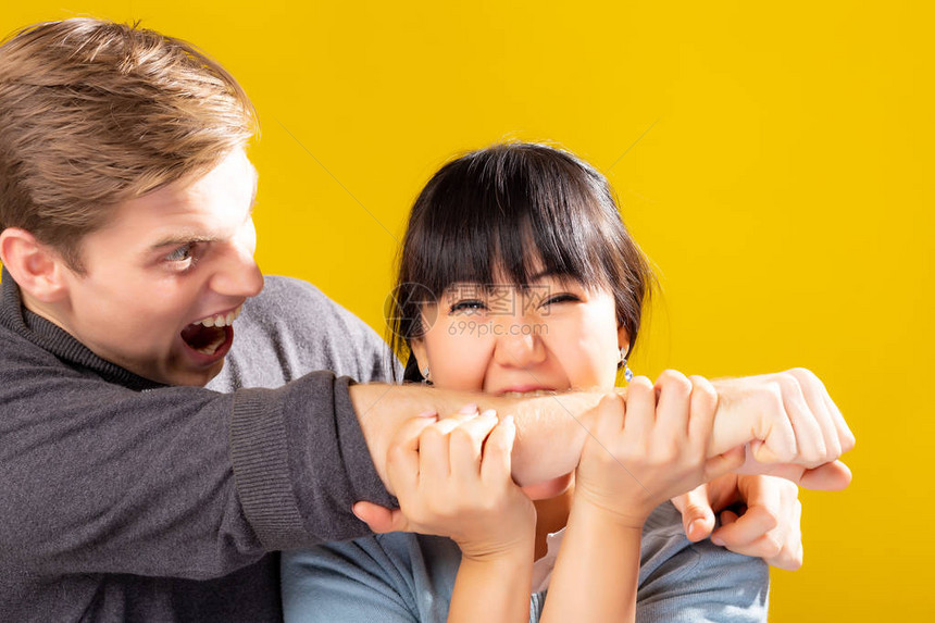 有趣的夫妇亚洲女友通过开玩笑来咬白人男友丈夫感到震惊讶尖叫受伤痛苦他们是幽默的一对亚洲女人饿了图片