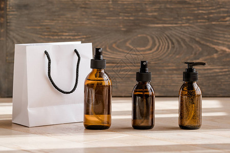 木制背景的化身深蓝玻璃瓶和白袋美容博客沙龙治疗概念品牌包装模背景图片