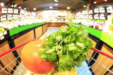 装满蔬菜的购物车在超市里图片