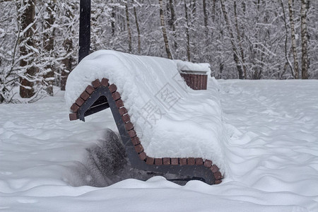 在一个城市公园的板凳上在大雪降图片