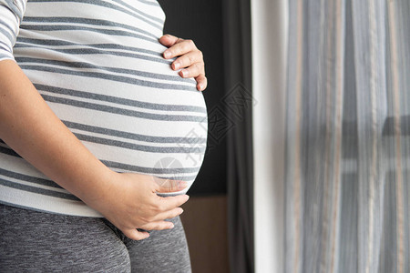 年轻漂亮的女人在家里的床上怀孕概念爱怀孕人和对卧图片