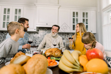 感恩节快乐一家人坐在桌旁庆祝节日祖父母和孩子传统晚餐图片