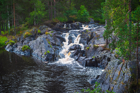 巨大的小瀑布在穿越森林溪流和从岩石上图片
