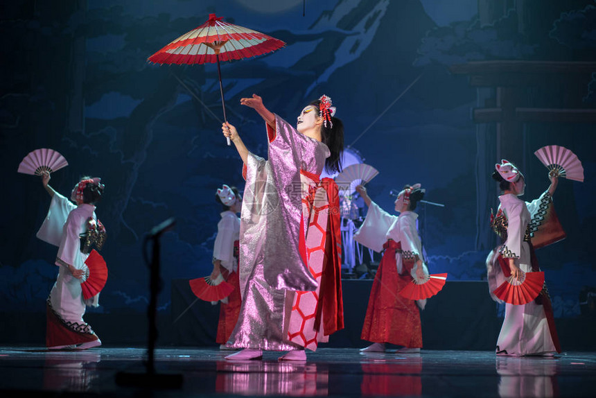 日本传统表演身着传统白色和红色和服戴着狐狸面具的女演员拿着图片