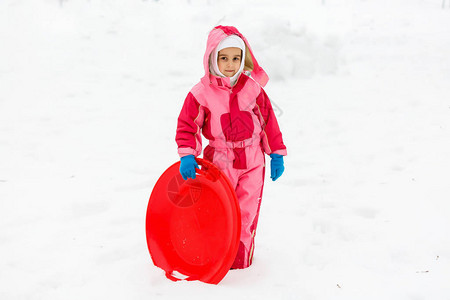 冬天骑雪滑梯的小女孩图片