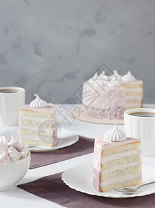 白盘上的一块蛋糕一杯茶蛋白酥皮图片