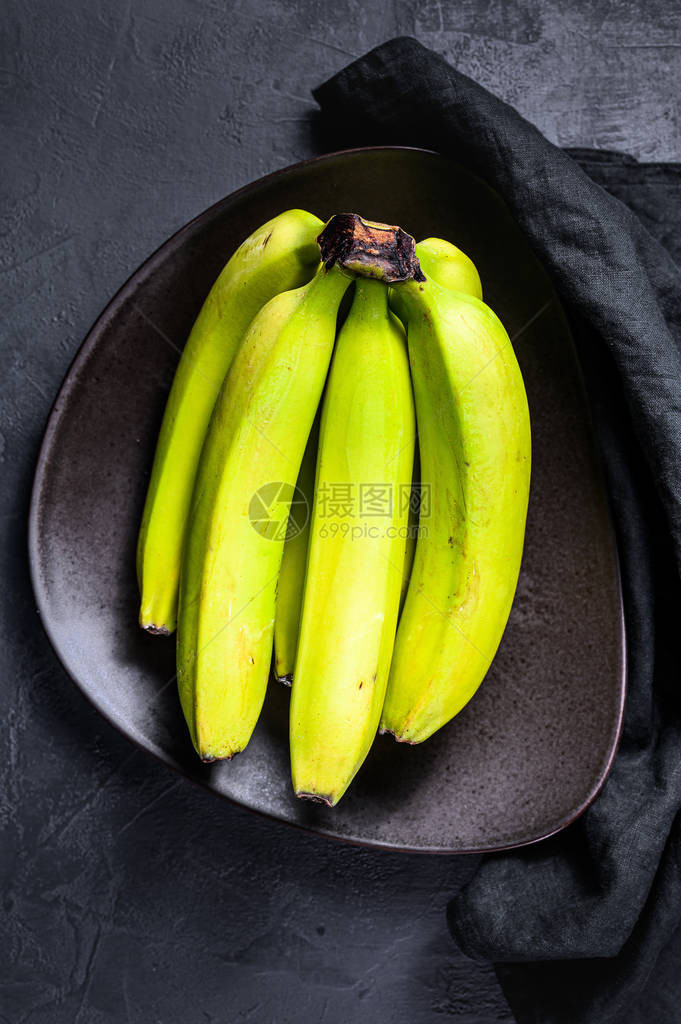 绿色香蕉在盘子上黑色背景顶层景图片