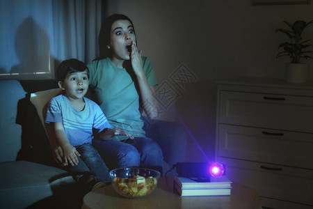 情感年轻女和儿子在家里用视频放映机观看电影文本空间Symplefor图片