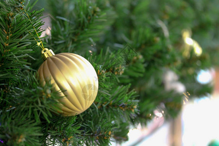圣诞枞树枝装饰着金色的小玩意明亮的节日装饰模糊的背景室内华丽的栏图片