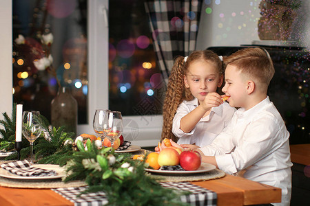 男孩和女孩庆祝新年喝果汁吃水果在新图片