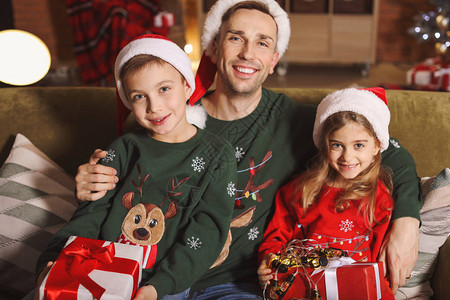 父亲和他的孩子在家带圣诞礼物回图片