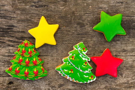以圣诞树和星为形状的节日圣诞饼干在生锈木制桌子图片