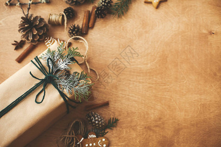 乡村木桌上有雪松枝的时尚质朴圣诞礼盒背景图片