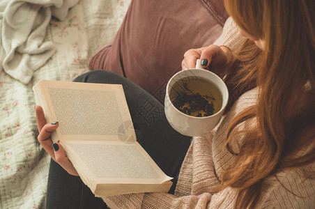 温冬秋天妇女喝热茶和阅读书图片