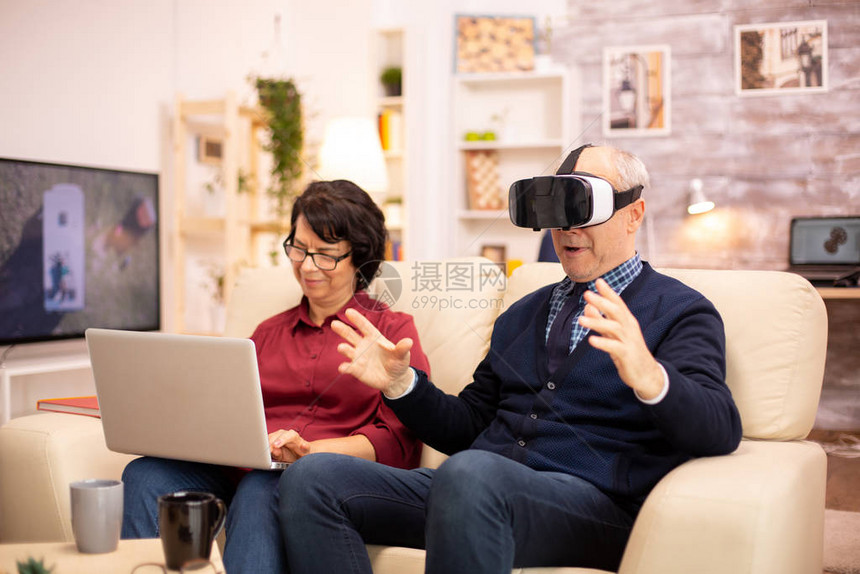 年老的退休老人在他们舒适的公寓里使用VR图片