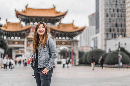 亚洲女游客在昆明金碧广场旅行时观望光图片