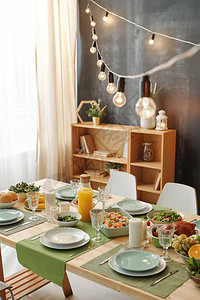 感恩节或圣诞节晚会的节日餐桌配有灯头挂在架图片