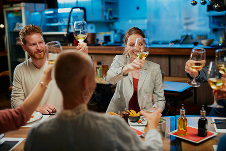 一群最好的朋友坐在餐厅吃饭用酒举杯图片