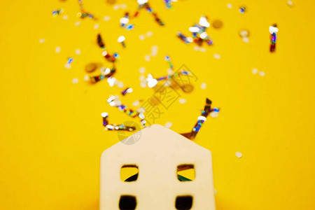 有五彩纸屑的白色玩具房子黄色背景复制空间庆祝新年新年房屋投图片