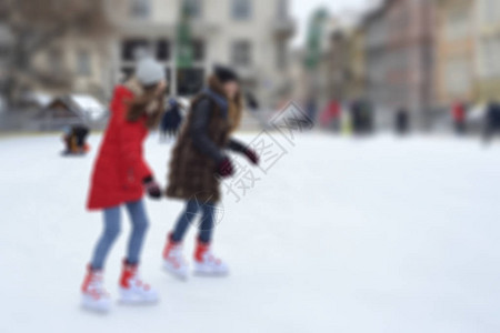 快乐的人在溜冰场户外溜冰冬季活动散焦的室外溜冰场与滑冰的图片