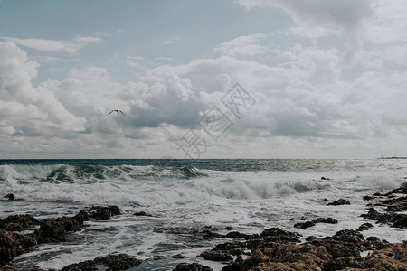 石头海滩浪天空与云彩图片