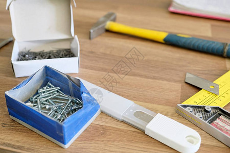 锤子钉子带刀片的文具刀用于组装家具的螺钉木背景图片