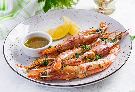 烤野生阿根廷红虾大虾配欧芹油大蒜和柠檬美味的食物图片