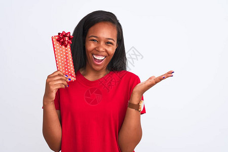 年轻的非洲裔美国女在与世隔绝的背景下拿着生日礼物非常高兴和奋图片