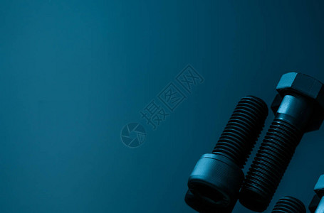 蓝色背景上的金属螺栓五金工具特写六角头螺栓和带复制空间的内六角螺栓汽车工程中使用的螺纹紧固件六角螺栓高背景图片