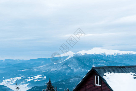 有松树和木屋的雪山风景图片