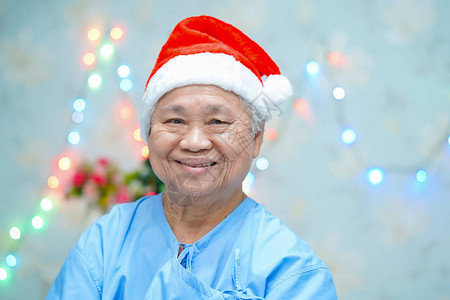 亚洲老年或老年妇人戴着圣诞老人助手帽图片