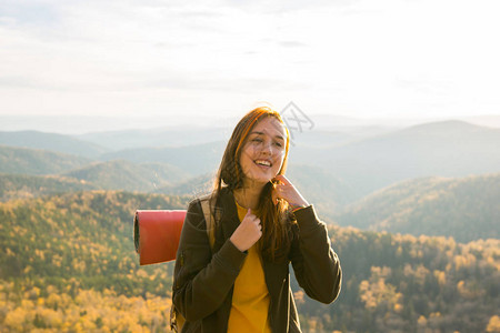 女在山丘的秋天森林中徒步旅行图片