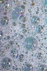 接近浴水泡沫作为彩虹黑中背景的BathWaterBlub图片