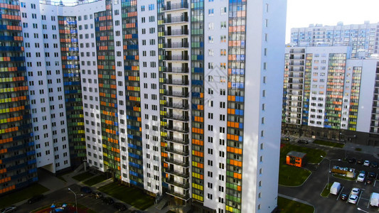 大城市睡眠区公寓楼建设空中带有蓝色橙色绿色和黄色玻璃阳图片