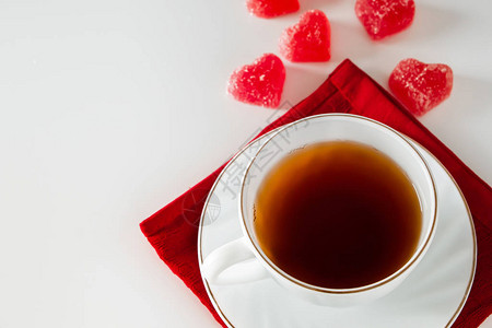 一杯白色背景的茶和一颗心形的红色果酱心形杯子里的烟概念图片