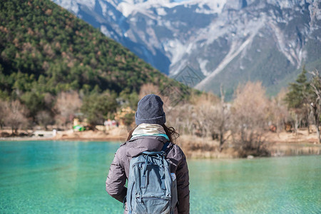 在丽江古城附近玉龙雪山景区内的地标和热门景点蓝月谷旅行的年轻女游客云南丽江独背景图片