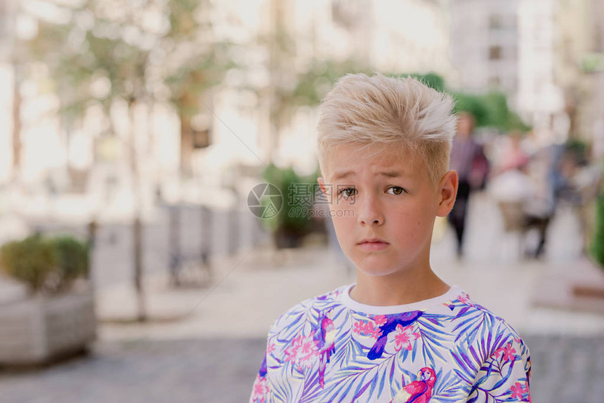 可爱英俊的金发十一岁男孩少年的肖像迷失在城市中长大图片