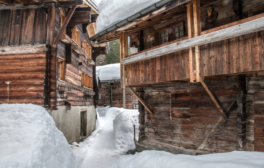 瑞士阿尔卑斯山谷的白雪覆盖的老木屋图片