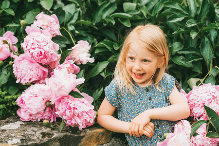 快乐可爱的5岁小女孩在小马花园玩耍的图片