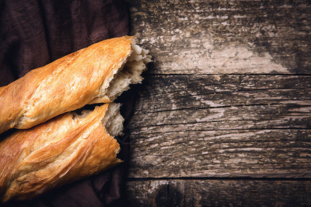 烘焙食品木制背景上的新鲜法式面包法国新鲜面包法式长棍面包图片