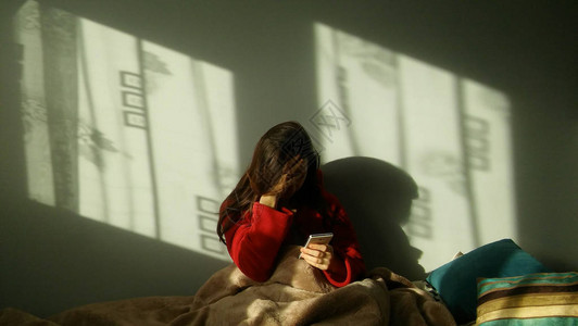 悲伤的女人在床上打电话沮丧沮丧的女人坐在图片