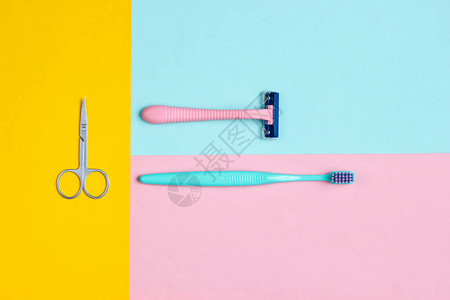 塑料剃刀牙刷指甲剪刀和彩色背景的剪刀图片
