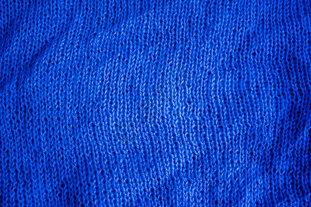 部分织物编织在编织针头上蓝色背景图片